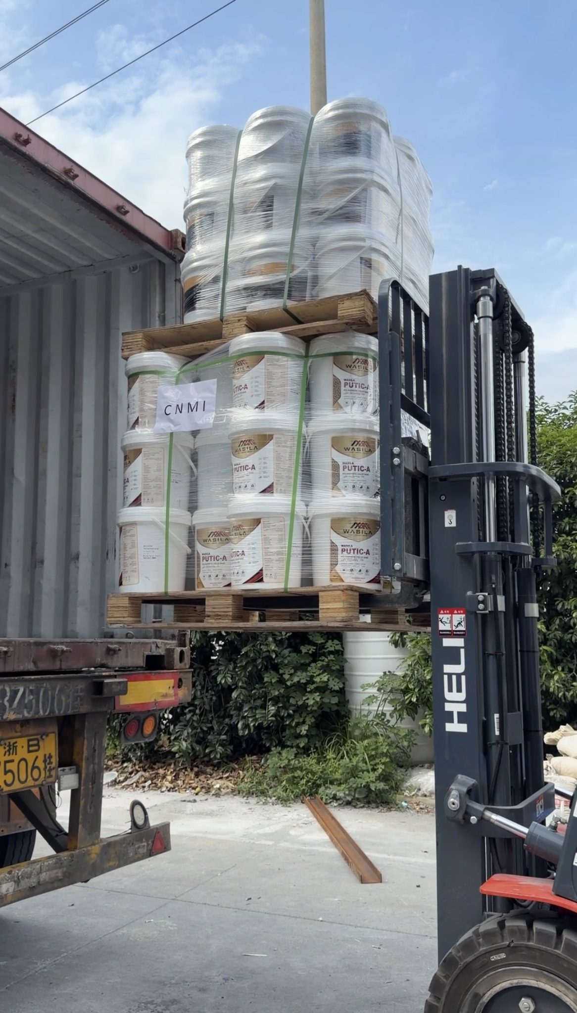 Forklift moving wrapped coating pallets for export shipment