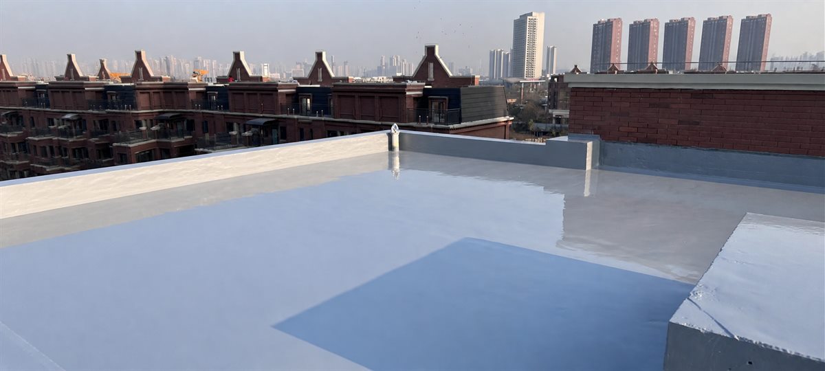 Finished gray roof coating system with surrounding buildings and skyline